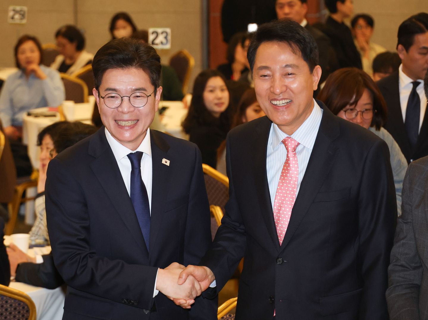 Seoul Mayor Oh Se-hoon, the People Power Party’s candidate, right, and Democratic Party Seoul mayor candidate Chong Won-o shake hands at an event held in Yongsan District, central Seoul, on April 22. [YONHAP]