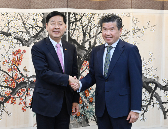Korea's Finance Minister Koo Yun-cheol, left, and James Kim, chairman of the American Chamber of Commerce in Korea take a photo after their dialogue on elevating Korea’s standing as a global financial hub at the Seoul government complex in central Seoul on April 28. [AMCHAM KOREA]