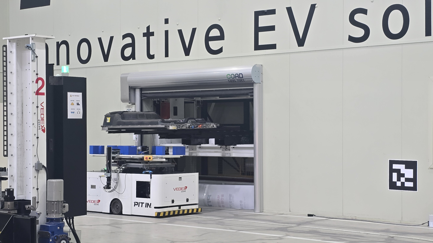 A machine at Pit In's facility moves EV batteries into charging systems. [LEE SOO-JUNG]