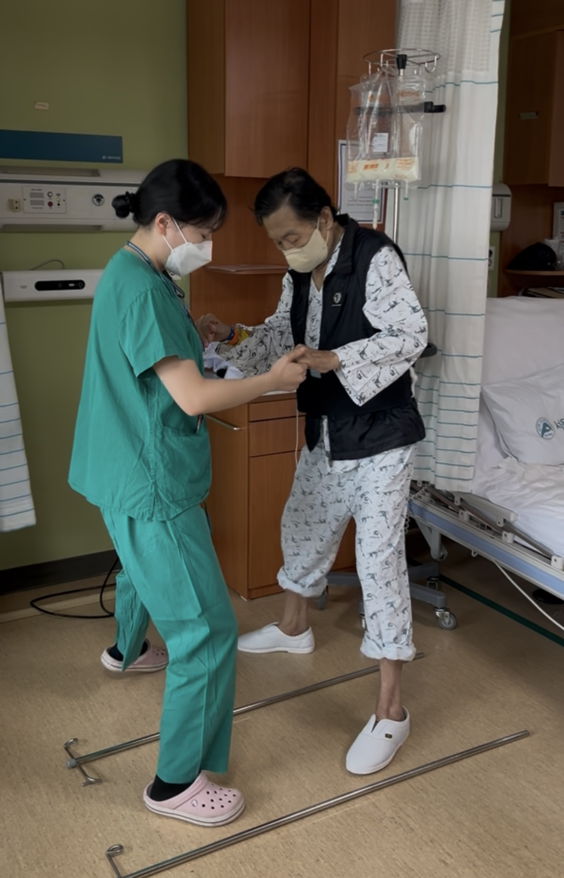A physical therapist, left, at Seoul Asan Medical Center assists a patient with walking therapy. The hospital provides early rehabilitation treatment during hospitalization. [SEOUL ASAN MEDICAL CENTER]