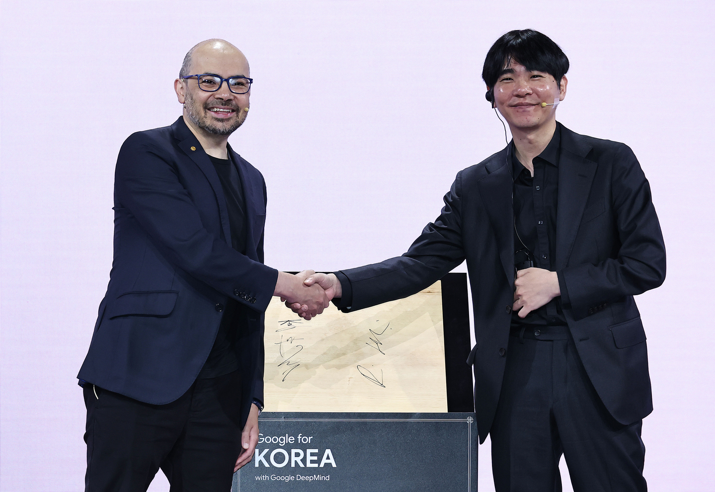 Demis Hassabis, the co-founder and CEO of Google DeepMind, left, shakes hands with legendary Korean Go player Lee Sedol at an event held in Seoul on April 29. [YONHAP]