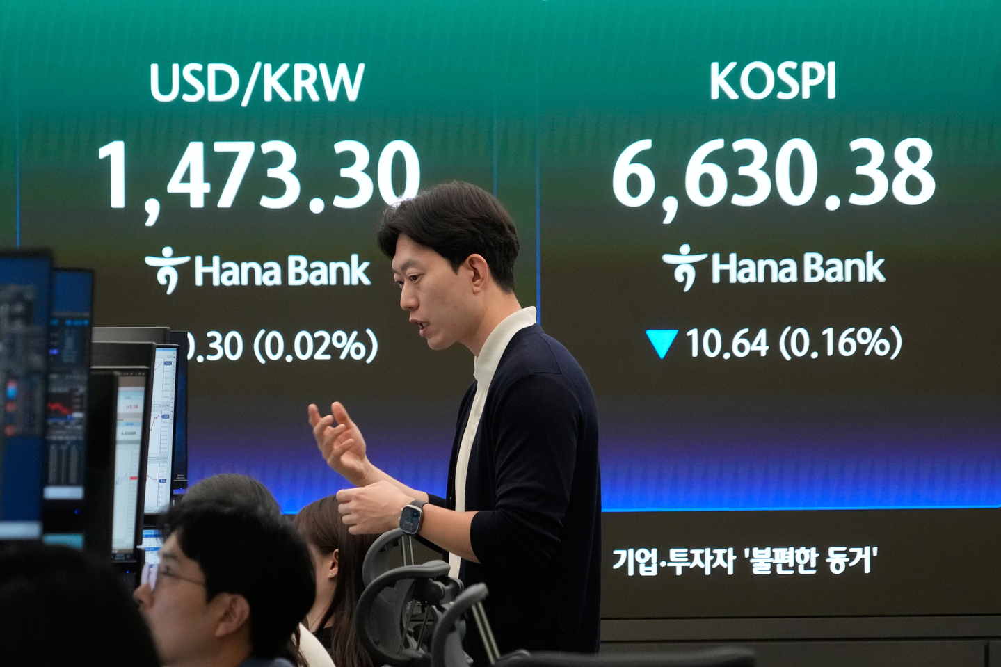 A currency trader reacts near a screen showing the Kospi and the dollar-won exchange rate at the foreign exchange trading room of the Hana Bank headquarters in central Seoul on April 29. [AP/YONHAP]