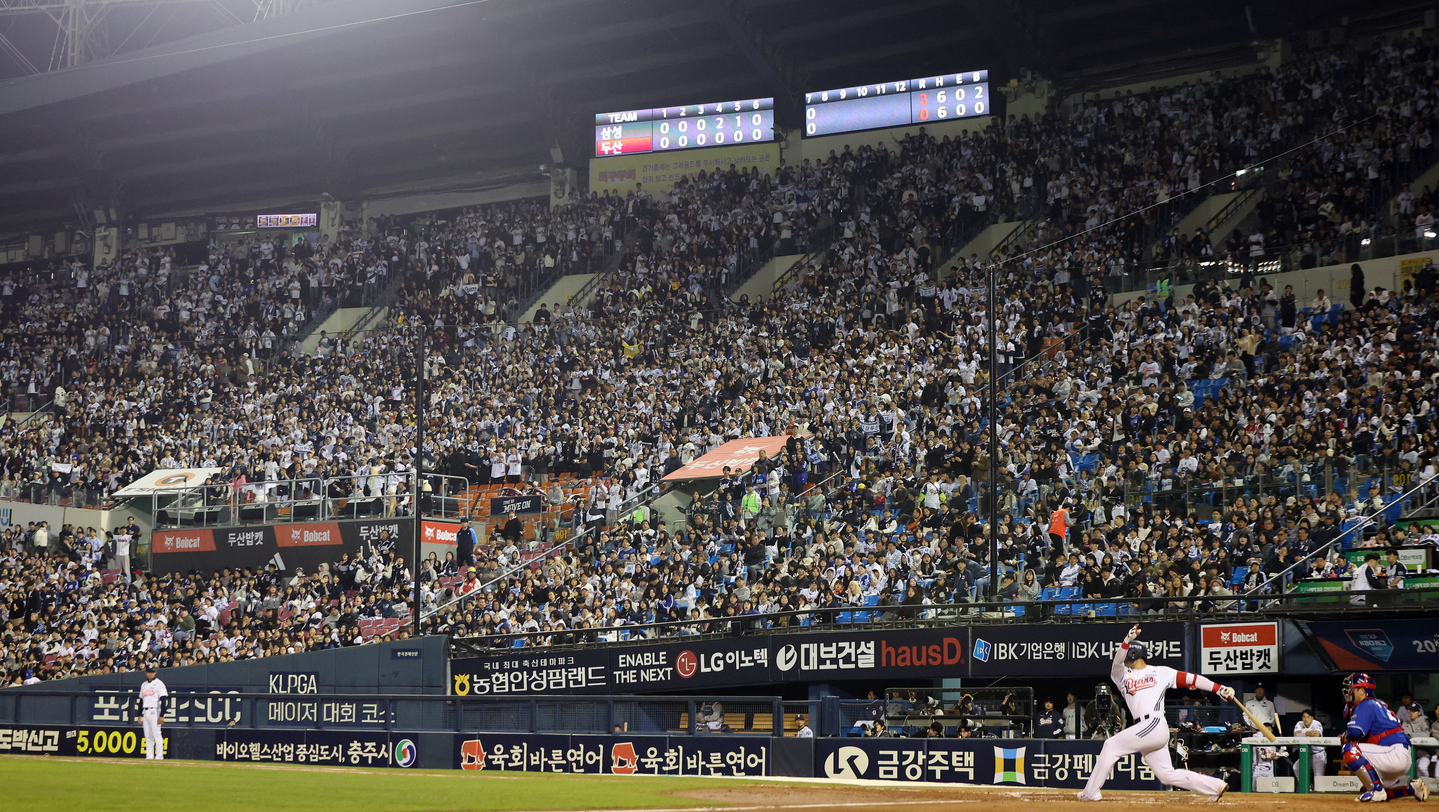 Doosan Bears fans cheer during a game with the Samsung Lions at the Jamsil Baseball Stadium in Songpa District, southern Seoul, on April 28. [NEWS1] 