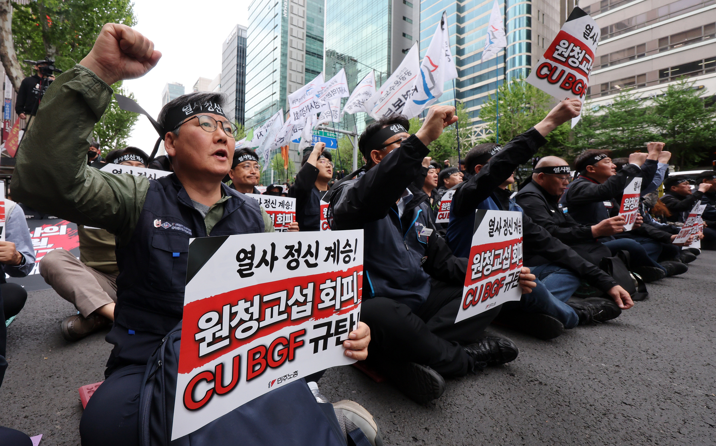 Unionized cargo workers chant during a rally held in front of BGF Retail headquarters in Gangnam District, southern Seoul, on April 28. [NEWS1]