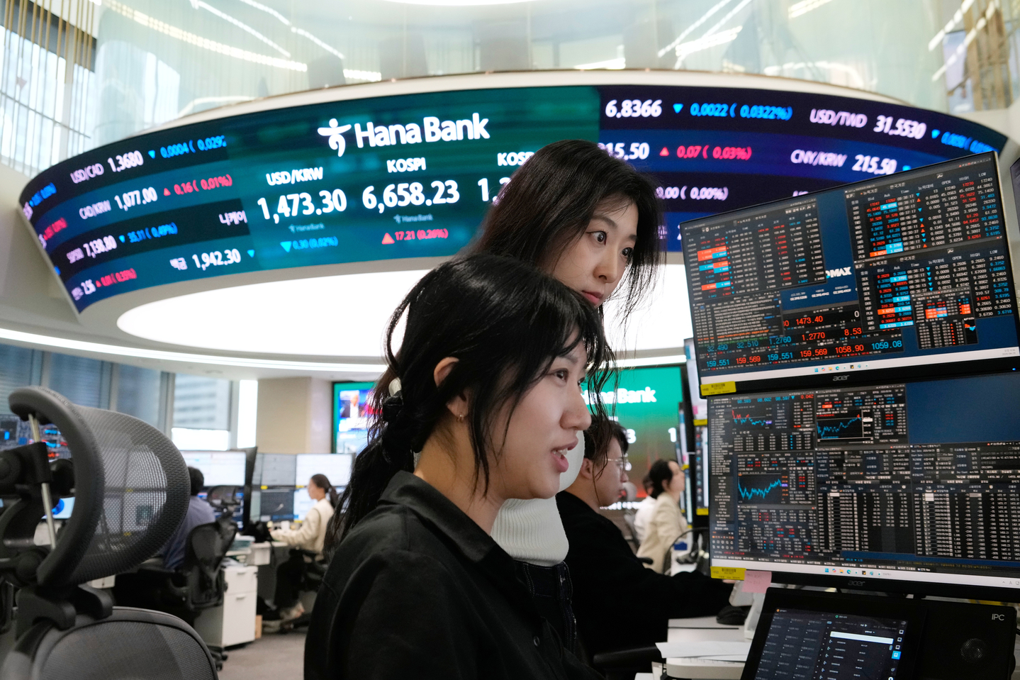 Currency traders work near a screen showing the Kospi and the dollar-won exchange rate at the foreign exchange trading room of the Hana Bank headquarters in central Seoul on April 29. [AP/YONHAP]