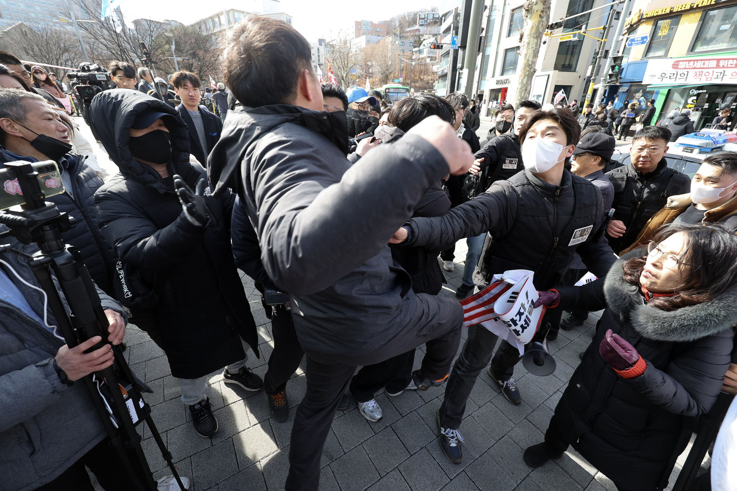 Rival rallies for and against the impeachment of former President Yoon Suk Yeol take place simultaneously in front of the main gate of Chung-Ang University in Dongjak District, southern Seoul, on March 3, 2025. Members of a civic group supporting the impeachment, left, and those opposing it exchange insults and shout at each other, leading to a physical confrontation. [KIM SUNG-RYONG]