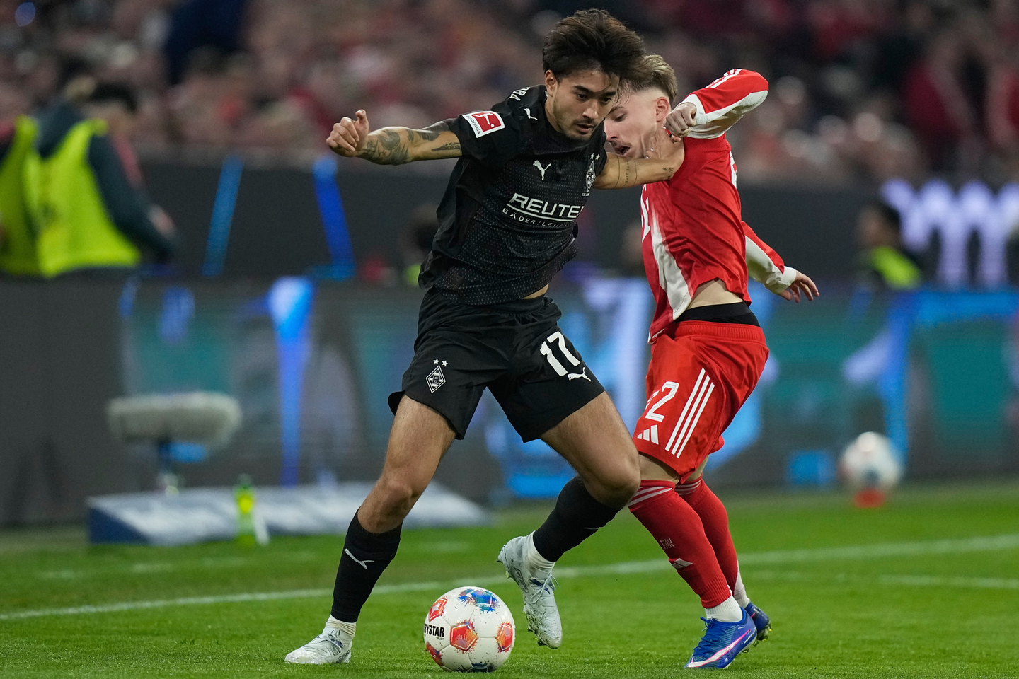 Mönchengladbach's Jens Castrop, left, and Bayern Munich's Lennart Karl challenge for the ball during a Bundesliga match in Munich on March 6. [AP/YONHAP]