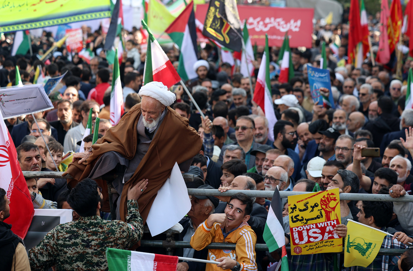An Iranian cleric jumps over a security fence during a rally to mark the 46th anniversary of the U.S. Embassy takeover, in Tehran, Iran, on Nov. 4, 2025. The rally commemorated the 1979 US Embassy hostage crisis, which began when Iranian students occupied the embassy after the U.S. allowed the late Shah to be hospitalized in the United States. The crisis lasted 444 days, ending on Jan. 20, 1981. [EPA/YONHAP]