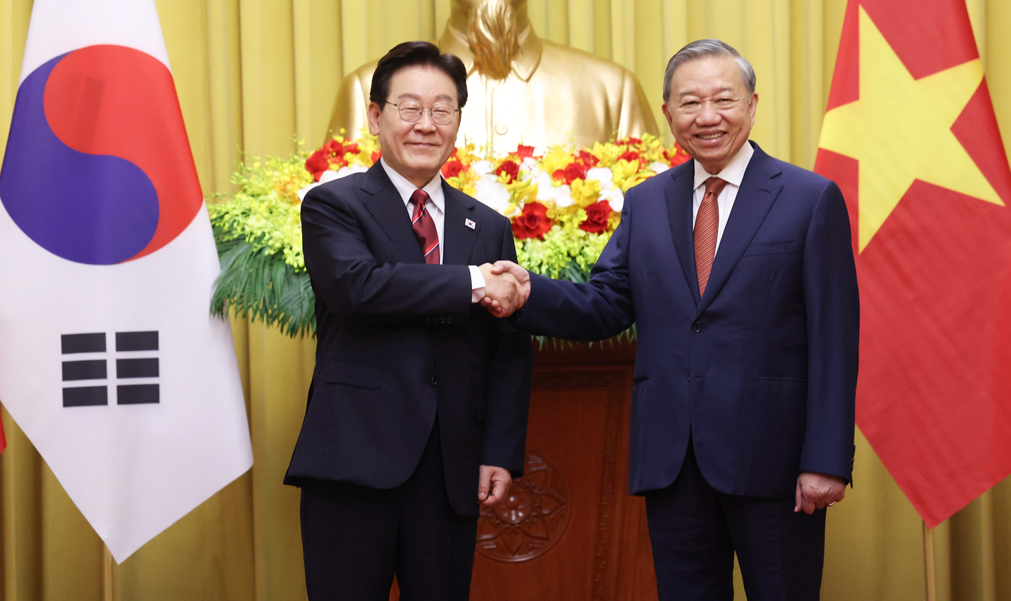 President Lee Jae Myung, left, shakes hands with To Lam, Vietnam's president and Communist Party general secretary, ahead of their bilateral summit at the presidential palace in Hanoi on April 22. [JOINT PRESS CORPS]