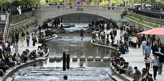 People relax along the Cheonggyecheon Stream in central Seoul on April 29. [NEWS1] 