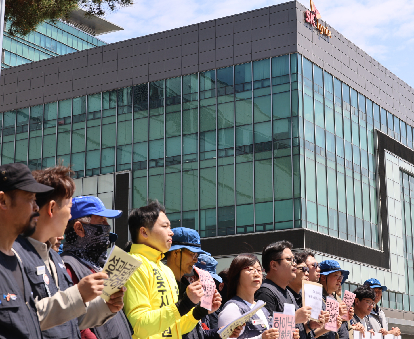 Workers from SK hynix partner firms and members of the Korean Metal Workers’ Union under the Korean Confederation of Trade Unions chant slogans during a press conference calling for direct negotiations with the parent company in front of SK hynix’s Plant 3 in Bokdae-dong, Heungdeok District, Cheongju, on April 30. [YONHAP]