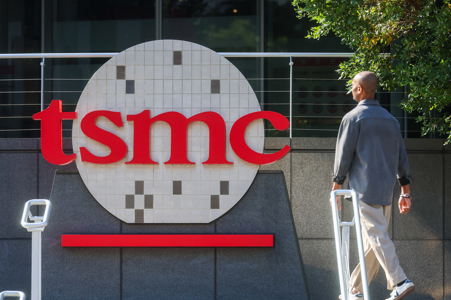A worker walks past the logo of TSMC, a Taiwanese multinational semiconductor contract manufacturing and design company, in Hsinchu, Taiwan, on Jan. 29. [AP/YONHAP]