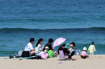 A family spends time on a beach in Gangwon on April 13. [YONHAP]    